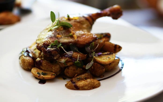 Duck confit served with vegetables at a restaurant in La Roque-Gageac.