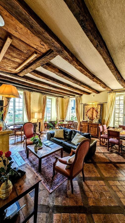 Elegant dining room at La Lanterne Chambres d'Hôtes in Sarlat, featuring antique furnishings and a beautifully set table.