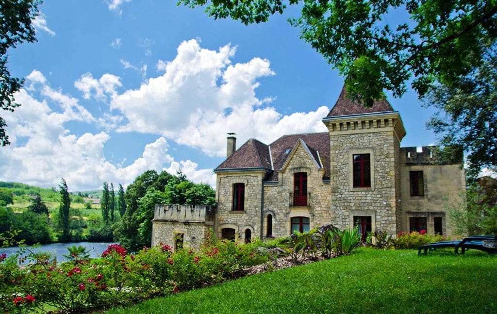 Château de La Malartrie overlooking the Dordogne River, with lush gardens and historical architecture.