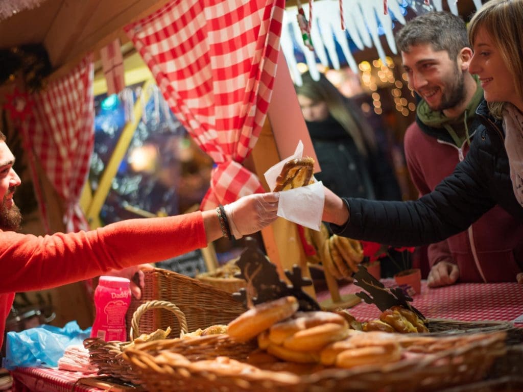 People receiving Christmas cookies at a market stall in Sarlat.