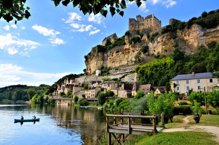 View of Beynac-et-Cazenac with the Dordogne River, featuring a castle perched on the cliff and charming medieval houses along the riverbank